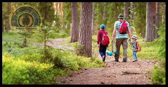 A dad walking two children on a forest path. An article on being a good dad.