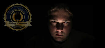 A sadistic looking man's face, dark lighting and black background. An article on sadists. 