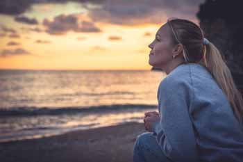 Woman smiling on beach. Hope theory a Flourishing Life Society Article
