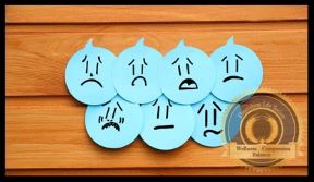 PictureFive paper heads with different unhappy expressions against wood background