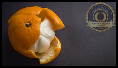 Garlic hidden beneath an orange peal, signifying deception.
