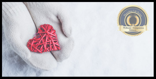 Two white mittens gently holding a red heart in the snow. A Flourishing Life Society article on  loving again after the hurt
