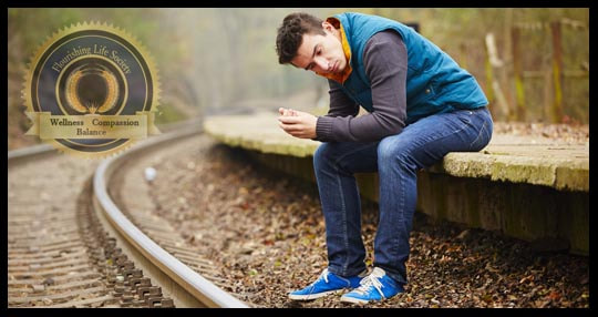 Young man sitting, lost in sorrowful thought. A Flourishing Life Society article on mild depression